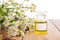 Massage oil in a glass bottle with camomile flowers on wooden ta