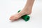 Massage roller for effective massage of acupuncture points of the foot under the foot on a white background