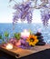 Massage stones with candles, daisy and wisteria