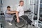 Massage therapist checks posture of patient with disability in gym