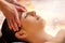 Massage therapist touching sensitive area between eyes on woman.