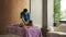 Masseur in luxurious spa makes woman massage her back.