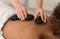 Masseur placing stone on back of woman