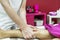 A masseuse applying lymphatic drainage to a patient\'s leg on a table in a cabin with red walls