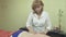 Masseuse make medicative massage of back to adult thick woman in saloon.