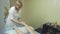 Masseuse make relaxing massage of left feet to young woman in saloon. Stroking