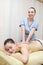 Masseuse makes massage to a alluring woman