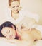 Masseuse massaging shoulders and neck of adult woman