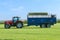 Massey Ferguson tractor pulling a trailer in grass field