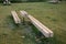 Massive bench in the park under a tree in the park urban style beam shape on metal legs in the square. grass grate made of metal a