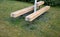 Massive bench in the park under a tree in the park urban style beam shape on metal legs in the square. grass grate made of metal a