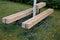 Massive bench in the park under a tree in the park urban style beam shape on metal legs in the square. grass grate made of metal a