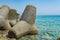 Massive concrete tetrapods form in the green water sea, Greece