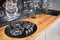 Massive cottage urban rustic loft style kitchen interior with round hob with three burners in wooden finish and granite with chalk