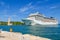 A massive cruise ship pulls near the Sailors Monument in the cruise port and harbor at Brindisi, Italy