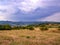 Massive dark heavy rain clouds over a hilly landscape with a town in the valley