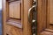 A massive double-leaf wooden door of an old house with a heavy bronze or brass handle