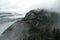 The massive granite rock appears through the mist