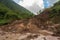massive landslide on a mountain slope, with debris and mud flowing down the hillside