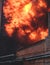 Massive large blaze fire in the city, brick factory building on fire, hell major fire explosion flame blast,  with firefighters