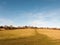 massive open plain farm field grass agriculture england blue sky ahead big empty path