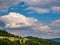 Massive rain clouds forming in the blue sky over hilly landscape