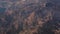 Massive rocky mountain summit peak sharp jagged cliff edge wide shot aerial, distant view out of the jet-plane window