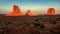 Massive sandstone pillars soar above iconic Monument Valley at sunset