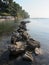 A massive stone breakwater creates a leading line toward the sprawling. Calm waters reflect gray skies and a warm palette of color