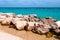 Massive stones rocks lying on the beach as a border between pebble beach Spiaggia del Frate and Adriatic sea waves and flows.