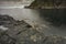 Massive structured steep stone wall with green moss and water