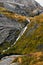 Massive structured steep stone wall with green moss and water at the bottom in the mountains on the Lofoten Islands in Norway