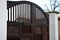 Massive two winged gate to the farmhouse. the upper part is fo the arc. Transparent top of the filling formed by wooden slats. Bar