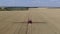 Massive wheat field, self propelled sprayer with long boom is watering plants