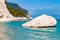 Massive white boulder as a sea stack lying in water of Adriatic sea with beautiful coastline of Numana, Italy on the background.