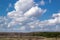 Massive white cumulus clouds in the blue sky over the forest