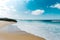 Massive wild beach with a wave of sea entering the sand during a sunny day with a super bright sky