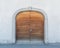 Massive winged wooden door in a stone wall with a granite door arch