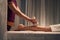 Massotherapist giving hot compress leg massage to female