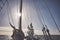 Mast of an old schooner sailing at sunset