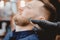 Master barber removes hair from nose of man with wax, depilation beauty procedure