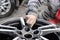 Master body repair man is working on preparing the surface of the aluminum wheel of the car for subsequent painting in the