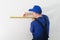 Master builder in uniform of measuring distances on wall with a tape measure