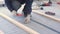 Master carpenter mounts pine wood floor - eco-friendly flooring. screwing lag to concrete.