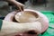 A master ceramist with 13 years of experience made plate from red clay on a potter`s wheel, on a sheet of particle board