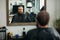Master cuts hair and beard of men in the barbershop, hairdresser makes hairstyle for a young man