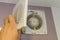 The master disassembles a wall-mounted household fan in the bathroom for service