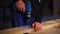 Master is drilling holes in a wooden particle board in a workshop of joinery