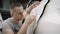 The master glues a white protective film on the car body. Car service worker glues anti-gravity film on the car body in