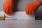 Master gluing  floor plinth to the wall, hands in gloves close-up